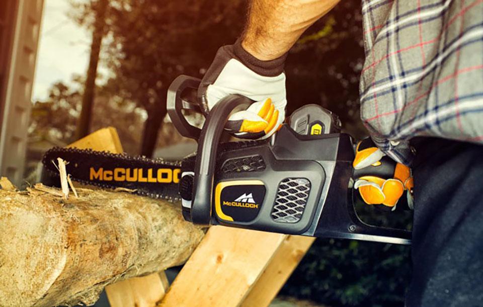 mcculloch chainsaw Man using a McCulloch chainsaw to cut a tree log